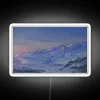 Neon sign displaying colorful RGB peaks against snowy mountain background.