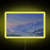 Neon-lit mountain peaks under a snowy landscape with vibrant colors.