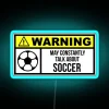 Neon soccer stadium sign with colorful RGB lights illuminating a blue-lit field.