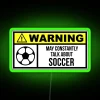 Neon green soccer sign under dimmed stadium lights, emphasizing excitement in sports culture.