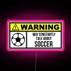Soccer stadium illuminated at night with vibrant pink neon lights.