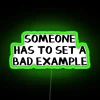 Vibrant neon sign with bold green letters spelling out 'Someone Has to Set a Bad Example'