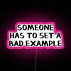 Neon sign with pink letters reading 'Someone Has to Set a Bad Example'