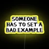 Neon sign reading 'Someone has to set a bad example'