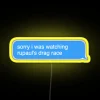 Neon sign in bright yellow with a playful apology message referencing RuPaul's Drag Race.