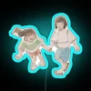Spirited Away's Chihiro and Haku standing in front of a vibrant neon sign, set against a dark blue background.