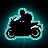 Neon-lit sport bike silhouette at night against a blue cityscape.