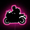Sleek sport bike silhouette illuminated by neon pink sign
