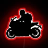 Red sport bike neon sign at night, illuminated by a vibrant glow.