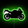 Neon-lit sport bike silhouette under a green sign at night