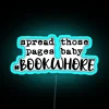 Neon sign reading 'Spread Those Pages Baby'