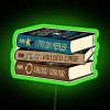 Stack of fantasy novels, The Prison Healer trilogy cover art, with RGB neon sign effects.