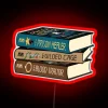 Stack of vibrant, neon-lit books with bold font reading 'The Prison Healer Trilogy'