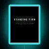 Neon sign with bold, blue letters reading 'Standing Firm' in a modern, RGB color scheme.