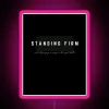 Neon sign with pink letters reading 'Standing Firm'