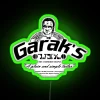 Neon sign reading 'Garak's A Plain and Simple Tailor' in a futuristic style inspired by Star Trek Deep Space Nine.