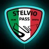 Motorcyclist riding through Stelvio Pass with LED neon sign illumination at night.