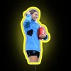 AFL player Steph Catley holding an AFL ball in front of a neon sign.