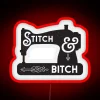 Neon sign featuring a sewing machine with colorful, glowing threads in a modern stitch-and-bitch shop atmosphere.