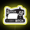 Neon sign with colorful stitching theme and sewing machine design, set against a yellow background