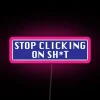 A neon sign reading "Stop clicking on sh*t" in pink letters.