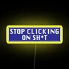 Neon sign with yellow letters reading 'Stop Clicking'