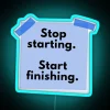 Neon sign with bold, blue letters displaying the phrase 'Stop Starting Finish'