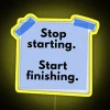 Neon sign with colorful letters spelling out 'Stop Starting, Start Finishing'