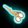 Glowing neon sign with gold letters featuring scissors on a stork silhouette