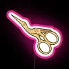 Neon sign with pink stork holding scissors and gold led lights in an RGB display.