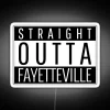 Neon sign reading 'Straight Out of Fayetteville' in bold, colorful letters against a dark background.