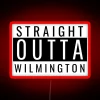 A vibrant neon sign reading "Straight Out of Wilmington" in bold, colorful letters at night.