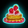 Colorful neon sign featuring a strawberry-shaped pancake design in vibrant RGB colors.
