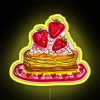 Strawberry pancakes under a colorful neon sign.