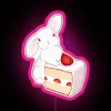 A neon sign with a rabbit holding a strawberry, in pink and blue hues.