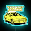 Neon sign reading 'Street racers don't need girlfriends, It'suki' in bold blue letters on a dark background.