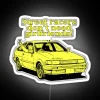 Neon sign in Japanese style with character Itsuki from street racing anime, promoting a humorous anti-love message.