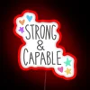 Neon sign with bold, vibrant letters reading 'Strong and Capable'