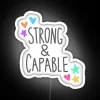Neon sign with bold, colorful letters reading 'Strong & Capable'