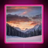 Vibrant sunrise over snow-capped mountains with colorful trees and neon hues in a picturesque winter landscape.