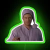 Dean Winchester from Supernatural starring Jensen Ackles posing in front of a colorful neon sign.