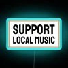 Neon sign with colorful, glowing letters spelling out 'Support Local Music'