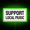 Neon sign promoting support for local music in a vibrant, green color scheme.