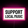 Neon sign with pink letters reading "Support Local Music" in bold, colorful font.