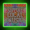 Neon sign reading 'Support Local Music' in green letters, reflecting colorful RGB hues.
