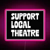 Neon sign promoting support for local theatre with pink hues.