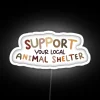 Neon sign reading 'Support Your Local Animal Shelter'