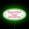 Neon sign with colorful letters reading 'Support Your Local Drag Queen'