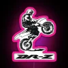 Suzuki DR-Z performing a wheelie in front of a neon sign