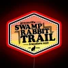 Neon sign on swamp rabbit trail with vibrant colors and futuristic glow.